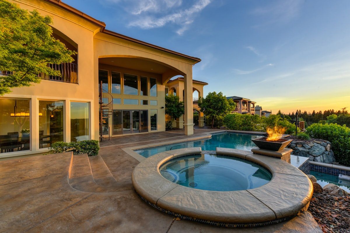 Estate home at dusk with pool